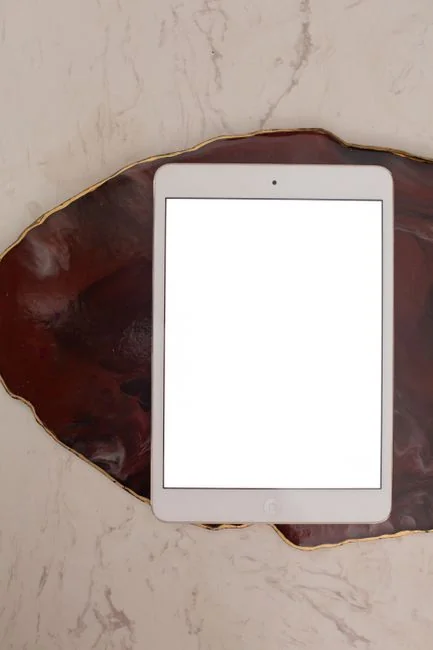 Mains qui pointent et touchent l’écran d’un ordinateur portable pendant une séance de planification sur une table en marbre.